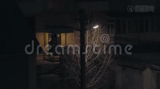 一个柱子上的灯笼在房子附近的夜晚发光，有人离开入口视频