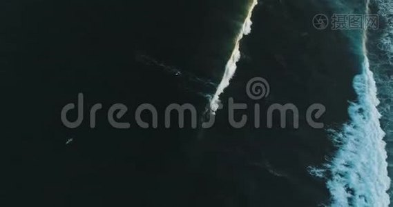 在晴朗的蓝色天气里，空中追踪拍摄于一位熟练的男性冲浪者，在海浪中乘风破浪视频