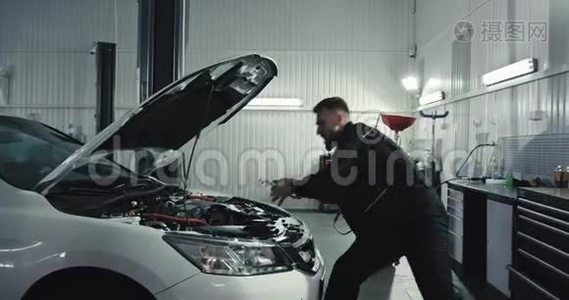 在一个现代化的汽车服务中心修完车后，穿着制服跳舞的机械师在跳舞视频