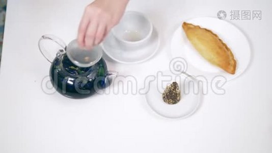 茶壶里的蓝色茶来自花朵，klitoria。时尚设计食品视频