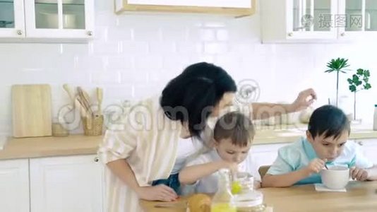 快乐的妈妈照顾她的儿子当他们吃饭。视频