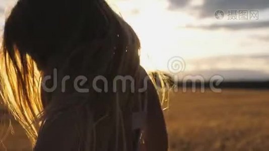 日落时分，欢乐的微笑女孩在迷离的大麦地背景下跳跃。 开心的笑孩子视频