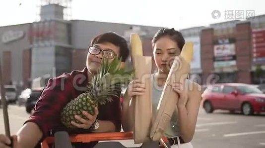 漂亮的越南夫妇在大超市附近用三明治滚筒和苹果做有趣的自拍视频