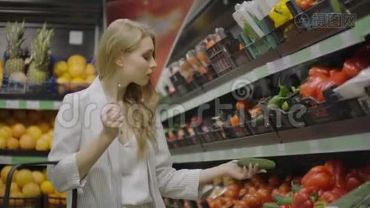 那个女孩，家庭主妇在超市购物。 把新鲜的西红柿放在树枝上，放进玻璃纸包里，系上领带视频