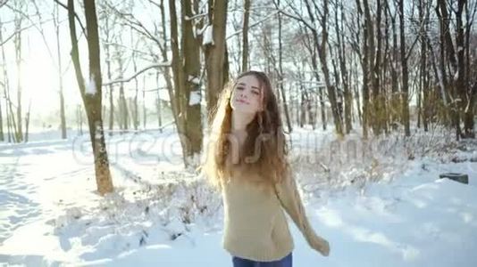 穿着毛衣的漂亮女孩在寒冷中玩得很开心。 一个穿着温暖衣服、穿着雪衣服的卷发少女视频