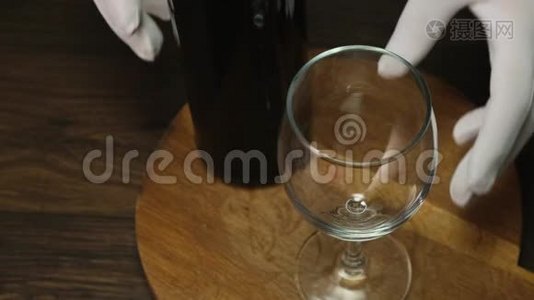 熟练的侍酒师把红酒从瓶子里倒进玻璃里。 快关门。视频