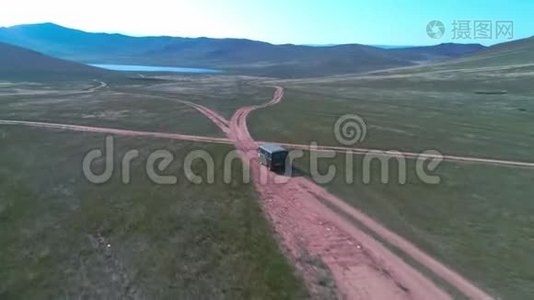 空中镜头拍摄与无人驾驶皮卡在草原。 汽车沿着草原行驶到西伯利亚，铺设道路视频