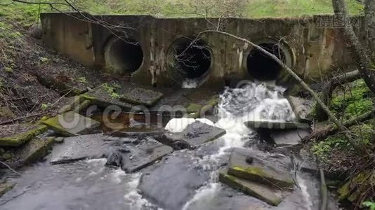 在一条有自来水的森林道路上，由桥下的管道组成的河坝。 高清录像。视频