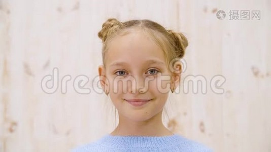 肖像快乐女孩少年微笑前镜头在灯光工作室背景。 特写脸满意的女孩看着视频