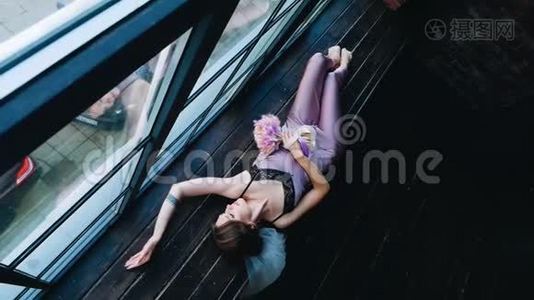 女孩躺在木窗台上。 从上面看到的。 性方面。视频