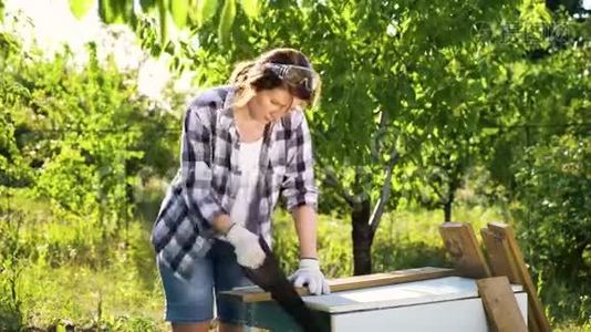 白人女性木工在阳光明媚的果园里锯木木板视频