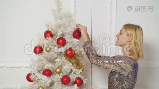 女孩装饰圣诞树。 圣诞快乐，假日快乐。 快乐的女孩在室内装饰圣诞树。 这就是视频