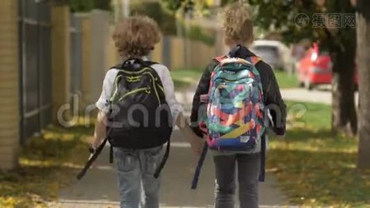 两个女孩和男孩在城市街道上走过汽车。 妹妹和她的哥哥回学校。 太阳在后台视频