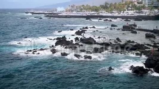 美丽的海景海浪打破黑色岩石和悬崖在海滨小镇。 克鲁兹港景观视频