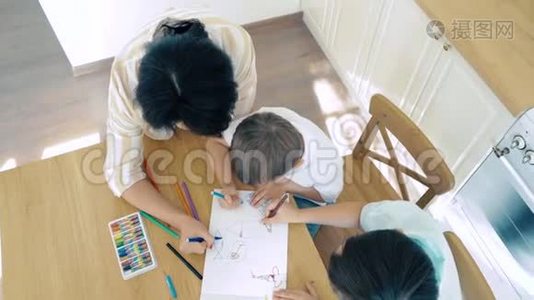 年轻的母亲帮助她的儿子用彩色记号笔画画。 学前教育。视频