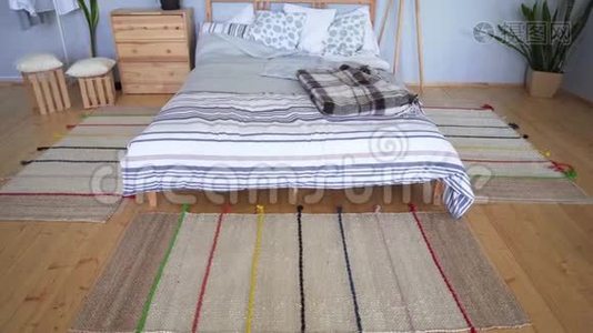 在斯堪的纳维亚风格的公寓里，白人女孩在一张木床旁拉起针织粉色袜子视频