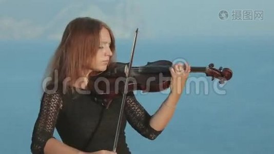 一位漂亮的小提琴手，穿着巫术服装，演奏着视频