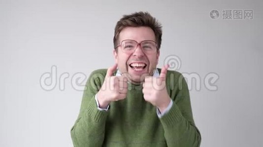 穿绿色毛衣的快乐男人竖起大拇指视频