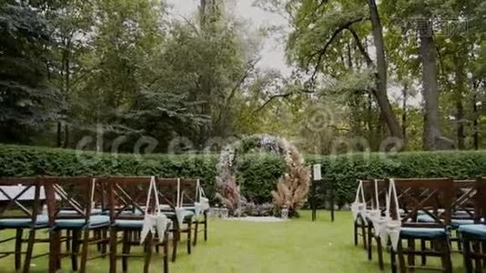 婚礼拱门和椅子装饰着森林里的天然花朵。视频