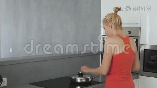 厨房里的女人在炉子上准备着一个煎锅，里面有扁豆和胡萝卜。 健康的饮食有很多视频