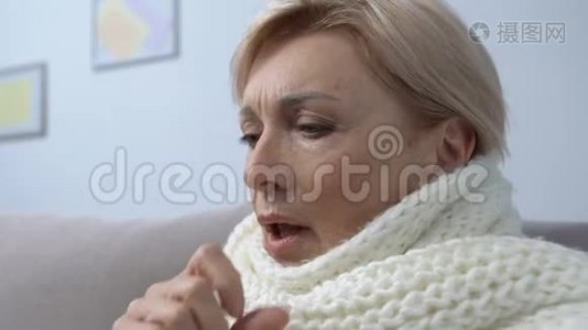 戴围巾、咳嗽、在家吃药片、感冒或感冒的老年女性视频
