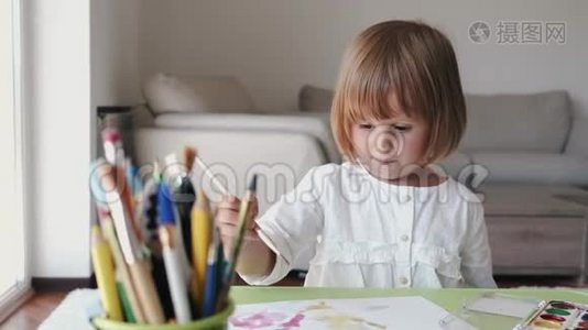 小女孩拿着画笔在家画画的肖像视频