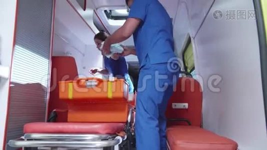 救护人员和护士把设备装在救护车里。视频