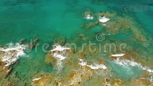 带石头和绿松石海波的悬崖海岸线的鸟瞰图。 垂直无人机视频