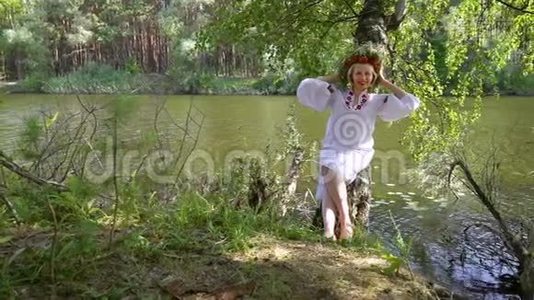 穿着乌克兰民族服装的漂亮女人靠在河边的桦树上视频
