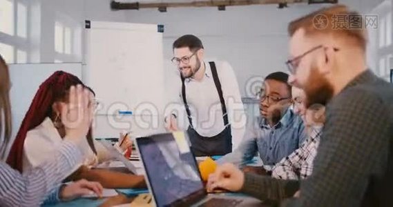 快乐男财务公司老板在现代办公室的团队会议上与同事一起制作挂图。视频