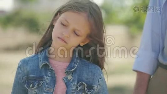 可爱有趣的小女孩在阳光下站在哥哥的背景上微笑着摆姿势的肖像视频
