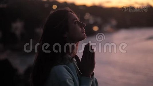 美丽的女孩祈祷仰望紫色的天空与希望，特写。 年轻女子梦中的剪影视频