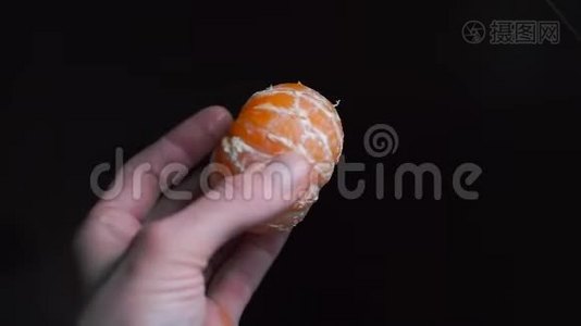 厨师手里拿着一`黑色背景的剥皮橘子视频