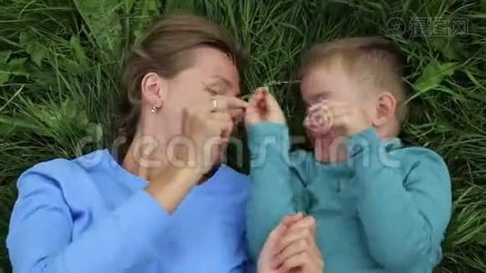 母子俩在草地上胡闹. 笑，开心视频