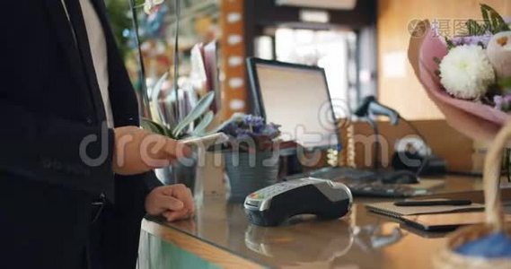 男性顾客用智能手机付款，然后从商店花店买花视频