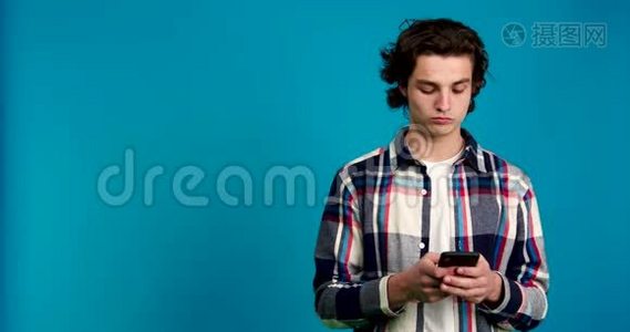 年轻男子在智能手机上打字，在蓝色背景下与外界隔绝视频