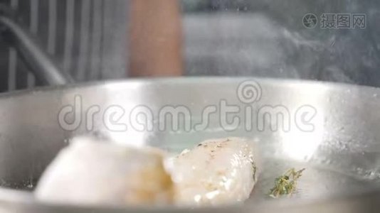 在电炉上用油在钢制煎锅中煮炸鱼片。 在慢动作中飞溅.. 餐厅视频