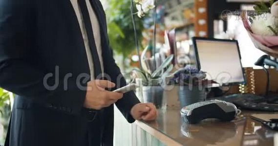 男人用智能手机在花店付款，然后拿花束视频