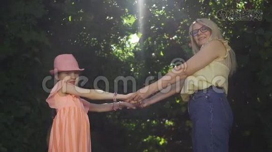 可爱的金发母亲和她的女儿一起呆在夏天的花园或公园里。 女人和女孩视频