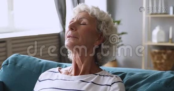 平静的老人放松呼吸沙发上的新鲜空气视频