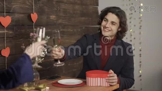 笑容可掬的男人着香槟酒杯和女友交换情人节礼物视频