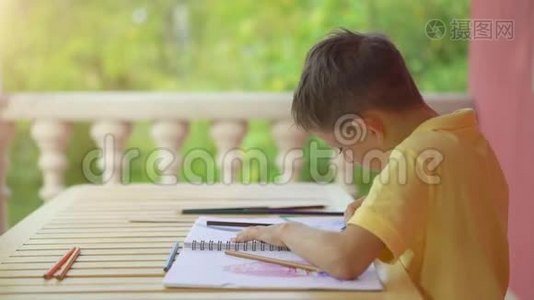 可爱的小男孩在他的绿色自然背景专辑中画画视频