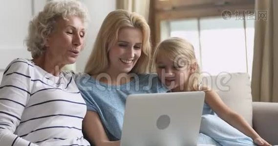 快乐的三代家庭使用笔记本电脑看有趣的卡通片视频