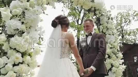 新娘和新郎为他们的婚礼誓言牵手。 新娘在婚礼上宣誓新郎。视频