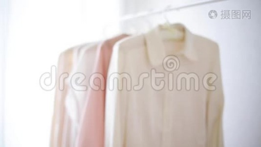 `白色衣架上穿粉色、米色和奶油色的女式服装视频
