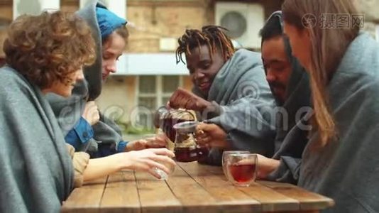 一群朋友坐在咖啡馆外面，用杯子倒茶视频