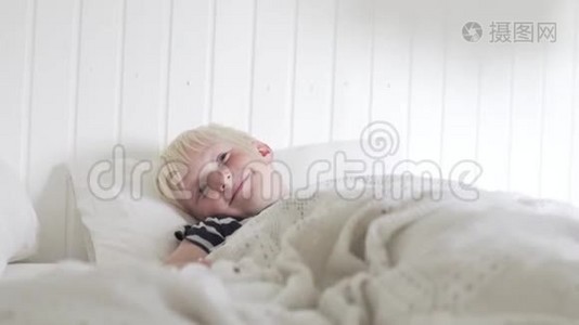 英俊的金发男孩早上躺在床上视频