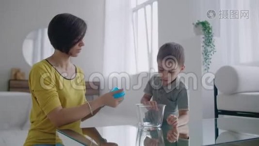 妈妈和儿子坐在地板上玩桌子，用弹性玩具笑视频