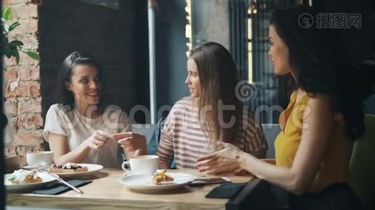 美丽的年轻女子携手在现代咖啡馆里欢笑视频