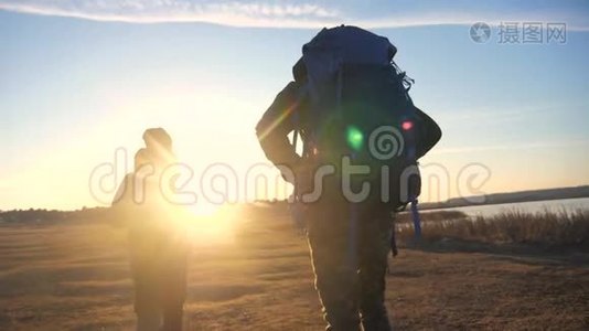 两位游客一起背着背包，慢动作走着，在阳光的照射下剪影生活方式视频